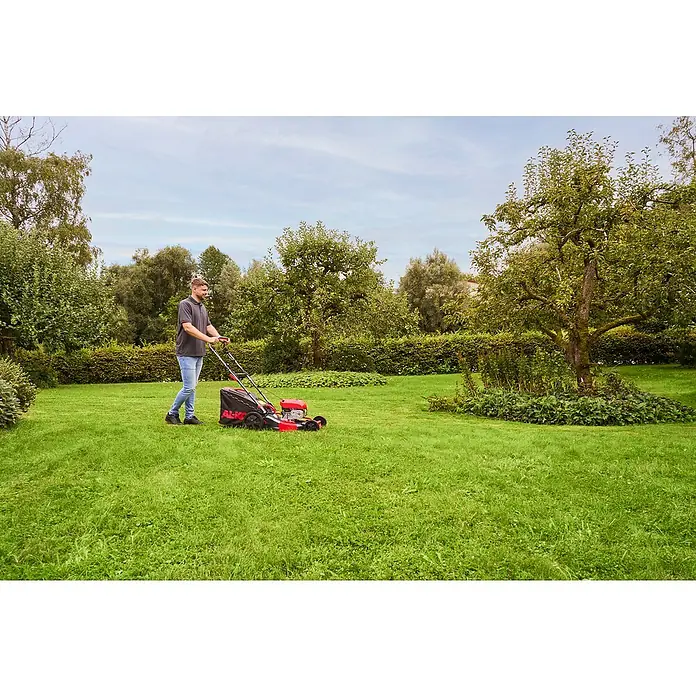 AL-KO Benzin-Rasenmäher Easy 5.16 SP-D - 2,6 kW, 171 cm³, Schnittbreite: 51 cm - Ein Mann mäht den Rasen mit einem AL-KO Rasenmäher in einem grünen Garten unter einem bewölkten Himmel.