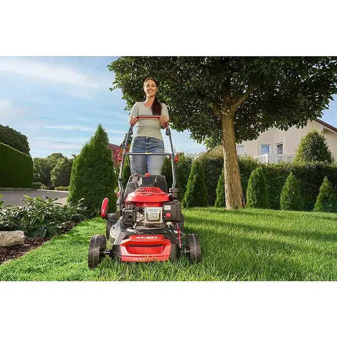 AL-KO Benzin-Rasenmäher Easy 4.16 P-D - 1,2 kW, 79,8 cm³, Schnittbreite: 41 cm - Eine Frau mäht den Rasen mit einem AL-KO Rasenmäher in einem gepflegten Garten. Der Rasenmäher ist rot und schwarz und steht im Vordergrund.