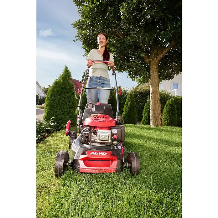 AL-KO Benzin-Rasenmäher Easy 4.16 P-D - 1,2 kW, 79,8 cm³, Schnittbreite: 41 cm - Eine Frau benutzt einen roten AL-KO Rasenmäher im Garten. Der Rasenmäher ist gut sichtbar und der Fokus liegt auf dem Produkt.