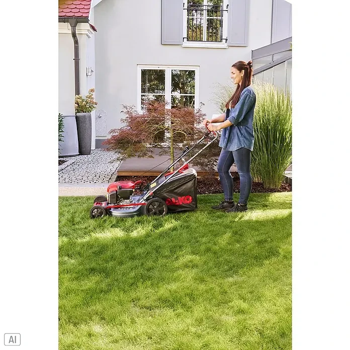 AL-KO Benzin-Rasenmäher Easy 4.66 P-D - 1,9 kW, 131 cm³, Schnittbreite: 46 cm - Eine Frau mäht den Rasen mit einem roten AL-KO Rasenmäher in einem grünen Garten neben einem Haus.