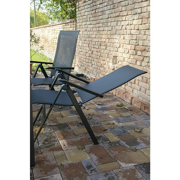Acamp Gartenmöbel-Set Urban/Chicago - 7 -tlg., Aluminium, Acatex, Schwarz - Bild von zwei grauen Gartenstühlen mit verstellbarer Rückenlehne auf einer Terrasse vor einer Backsteinmauer.