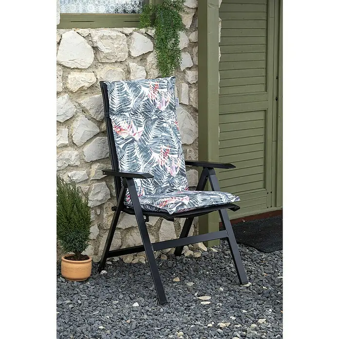beo Gartenmöbel-Auflage Tamky - Hochlehner, 4 Stk., L x B x H: 118 x 46 x 8 cm, Grün/Rosa - Gartenstuhl mit floral gemusterter Auflage vor einer Steinwand.