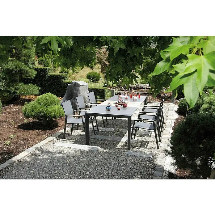 Acamp Gartenmöbel-Set Vegas/Woody Extension - 7 -tlg., Aluminium, Sicherheitsglas, HPL, Schwarz - Ein Gartentisch mit sechs Stühlen unter einem Baum. Das Set besteht aus wetterfesten Materialien und ist für den Außenbereich geeignet.