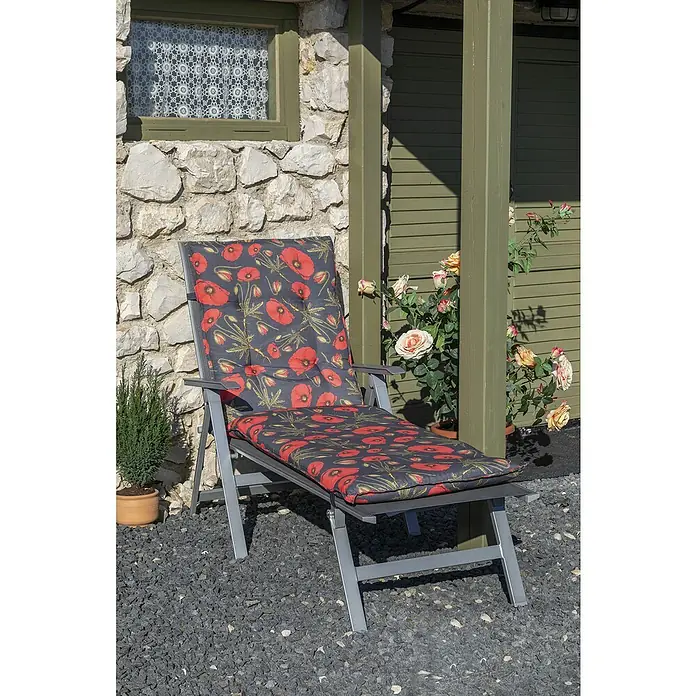 Gartenmöbel-Auflage Trondeim - Liegenauflage, 1 Stk., L x B x H: 191 x 58 x 8 cm, Baumwolle, Polyester, Schwarz/Rot - Gartenliege mit Mohnblumenmuster-Auflage vor Steinwand und Grünpflanzen. Ideal für entspannte Stunden im Freien.