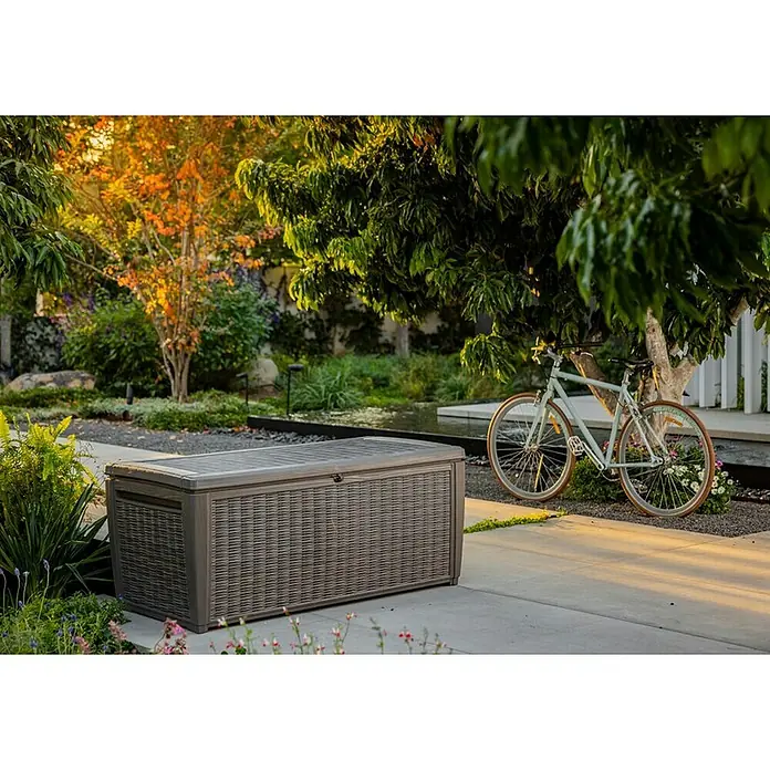 Keter Baúl para jardín Taiwan - L x An x Al: 73 x 145 x 64 cm, Marrón, Plástico - Esta foto muestra una elegante caja de almacenamiento exterior gris en un jardín, perfecta para guardar accesorios de jardín resistentes a la intemperie.