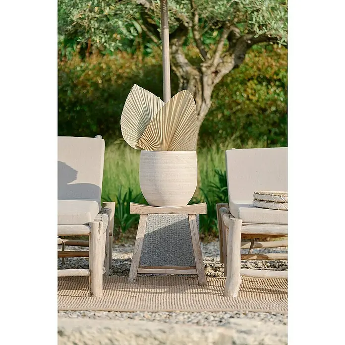 Maceta para planta Xat - Dimensiones externas (Ø x Al): 30 x 30 cm, Cerámica, Crema - Abanicos de viento decorativos en un jarrón de cerámica claro, colocados en una mesa auxiliar entre dos tumbonas.