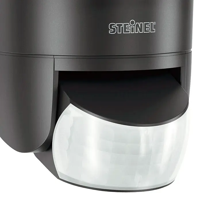 Steinel LED-Sensor-Strahler XLED home 2 S graphit - 13,7 W, L x B x H: 161 x 180 x 218 mm, Graphit, IP44 - Nahaufnahme eines Steinel-Bewegungsmelders in dunklem Gehäuse mit einem transparenten, halbkugelförmigen Sensor.
