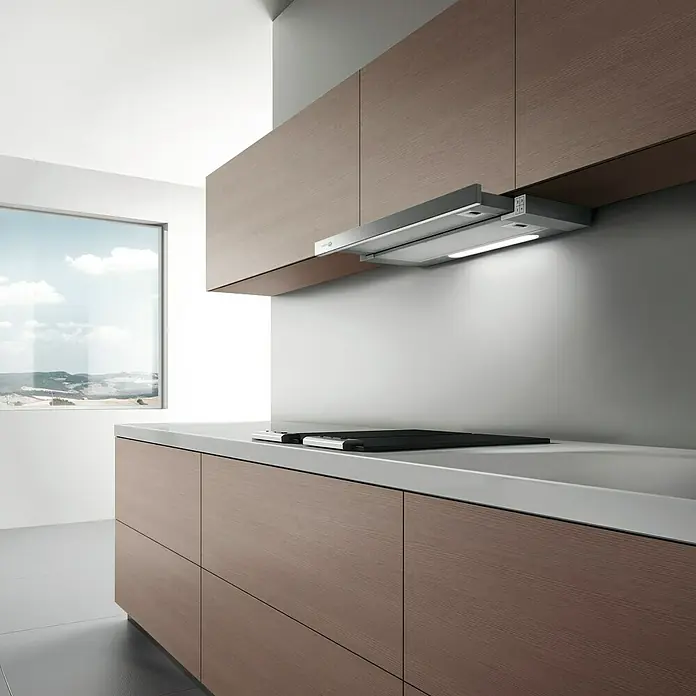 Turboair Campana extensible TT14 - Ancho: 60 cm, 304 m³/h, Acero inoxidable - Imagen de una cocina moderna centrada en la campana extractora bajo los armarios de madera. Luz brillante ilumina la superficie.