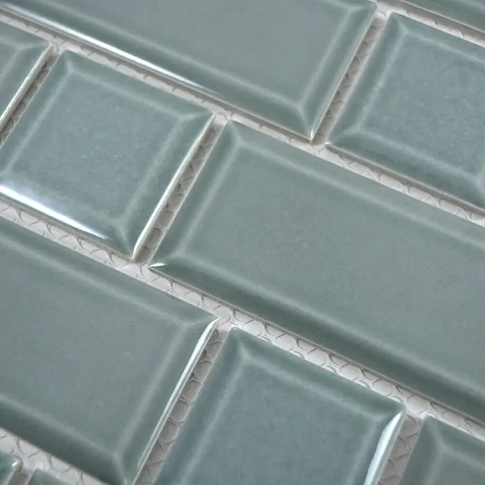 Mosaikfliese Metro Uni CG M06PM - 29,4 x 29,1 cm, Petrol, Glänzend - Nahaufnahme von blauen rechteckigen Keramikfliesen, die ein geometrisches Muster bilden und ein modernes Designelement darstellen.