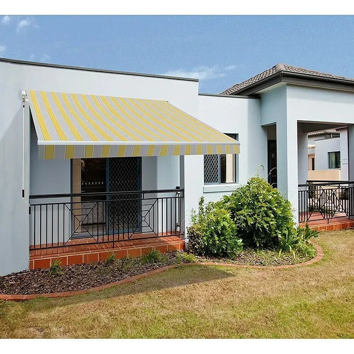 SmartSun Toldo de brazos extensibles Original Kit Poliéster - Amarillo / gris, Ancho: 4 m, Caída: 2,5 m - Toldo de rayas amarillas y grises. El toldo da sombra a un patio con una barandilla negra y una planta.