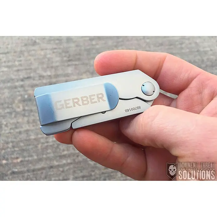 Gerber Cuchillo cúter E.A.B. Lite - Largo: 130 mm, Acero inoxidable, Plateado - Primer plano de una navaja plegable Gerber en la mano, destacando su marca y diseño compacto.