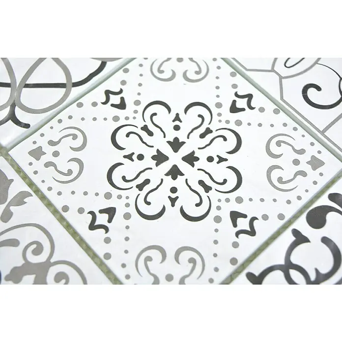 Mosaikfliese Crystal Retro XCM 8RBW97 - 30 x 30 cm, Weiß/Schwarz, Matt - Nahaufnahme von kunstvollen Keramikfliesen mit geometrischen und floralen Mustern in Grau- und Weißtönen, die eine elegante Oberfläche bilden.
