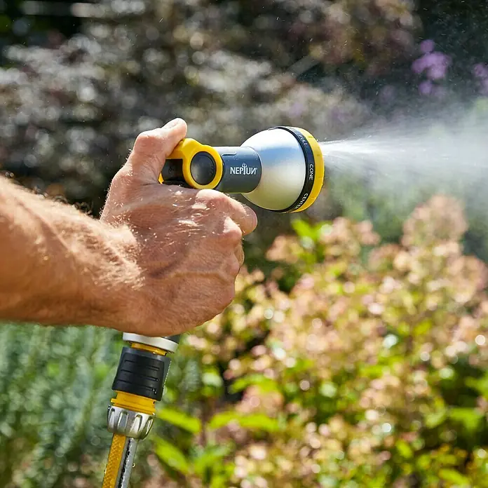 Neptun Profi Pistola multiuso - Aluminio/Plástico - Primer plano de una manguera de jardín Neptun rociando agua, utilizada en el jardín, perfecta para tareas de riego.
