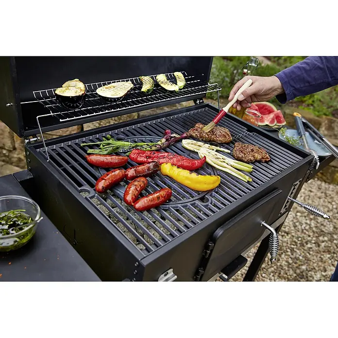 Kingstone KMS Barbacoa de carbón Black Angus XXL - Superficie de la parrilla (An x Pr): 70 x 43 cm, Negro - Una parrilla de carbón negra con salchichas, verduras y bistec untado con salsa. Disfrute de la deliciosa comida cocinada en la parrilla.