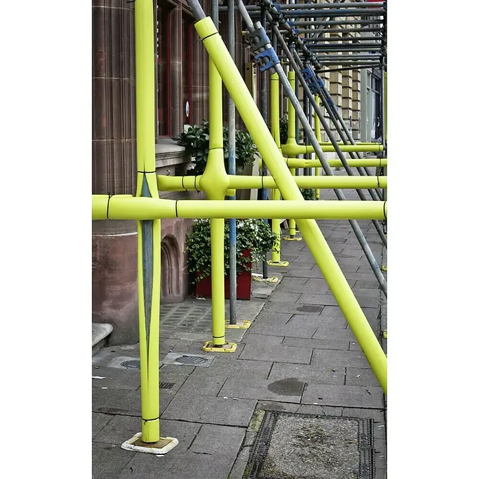Protector de espuma para andamios - Largo: 2 m - Cubiertas de seguridad amarillas en andamios frente a un edificio, aumentando la seguridad y evitando golpes.