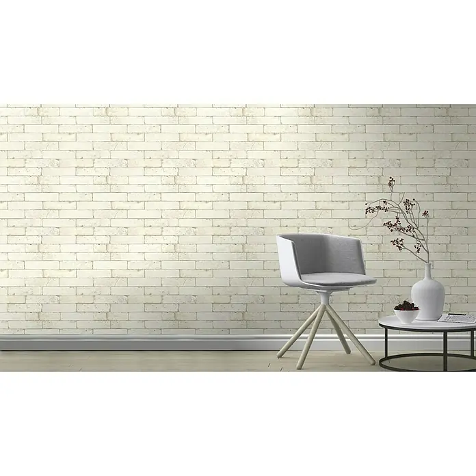 Rasch Vliestapete Factory 2 - Weiß, Steinoptik, 10,05 x 0,53 m - Nahaufnahme einer weißen Ziegelwandtapete in einem Raum mit Stuhl und Tisch, die eine elegante und moderne Atmosphäre schafft.