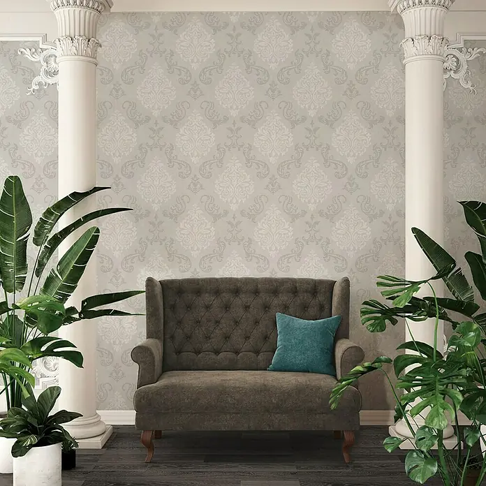 A.S. Création Vliestapete Memory 2 - Beige/Creme/Metallic, Ornament, 10,05 x 0,53 m - Elegantes Interieur mit grauem Samtsofa, türkisfarbenem Kissen, Säulen und grünen Pflanzen vor einer dezent gemusterten Tapete.