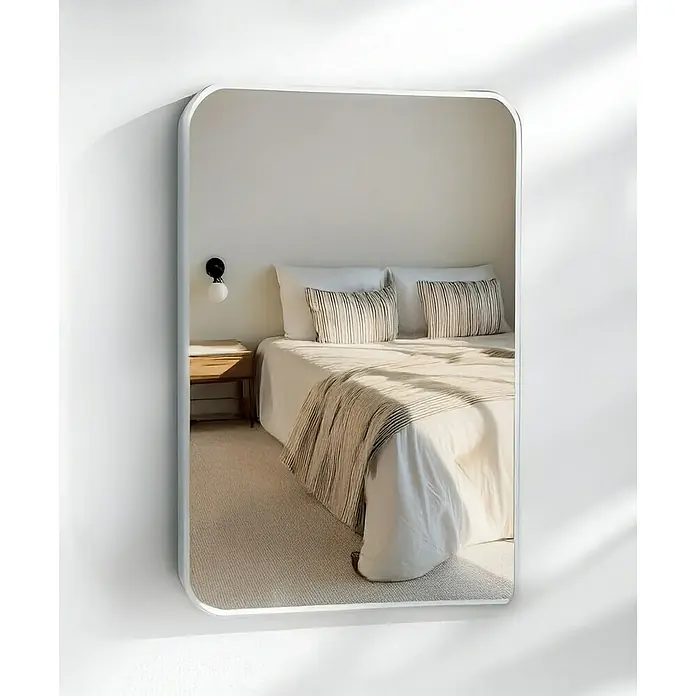 Espejo de pared Ovalado Zen - 45 x 70 cm, Blanco - Un espejo rectangular con bordes redondeados que refleja un dormitorio con cama, mesita de noche y alfombra.
