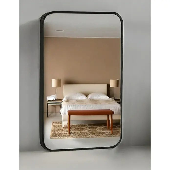 Espejo de pared Ovalado Zen - 45 x 70 cm, Negro - Un espejo rectangular moderno con bordes redondeados y un marco negro delgado que refleja un dormitorio.