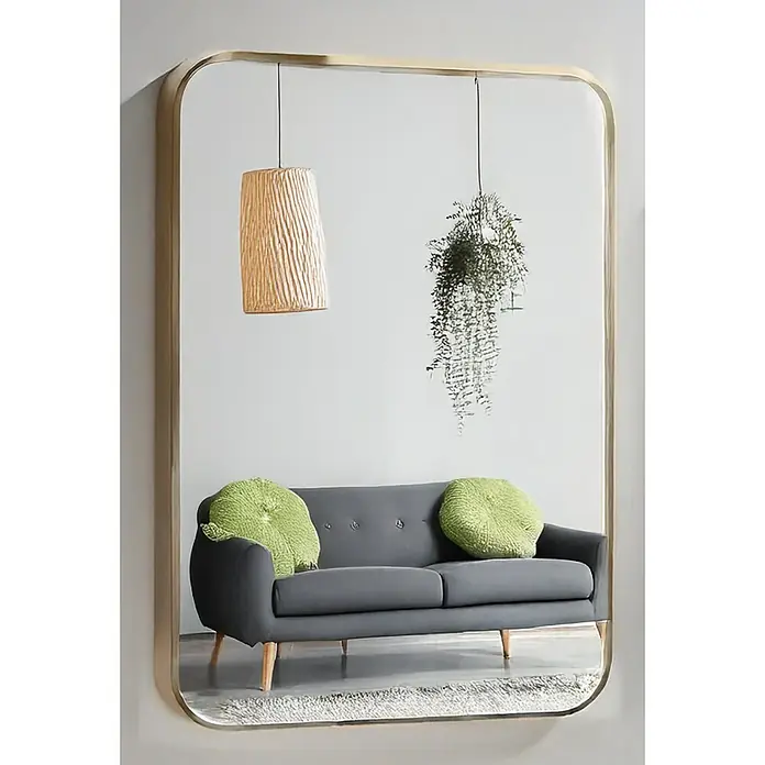 Espejo de pared Ovalado Zen - 100 x 165 cm, Oro - Un espejo rectangular con esquinas redondeadas que muestra un sofá gris con cojines verdes, una lámpara colgante y una planta.