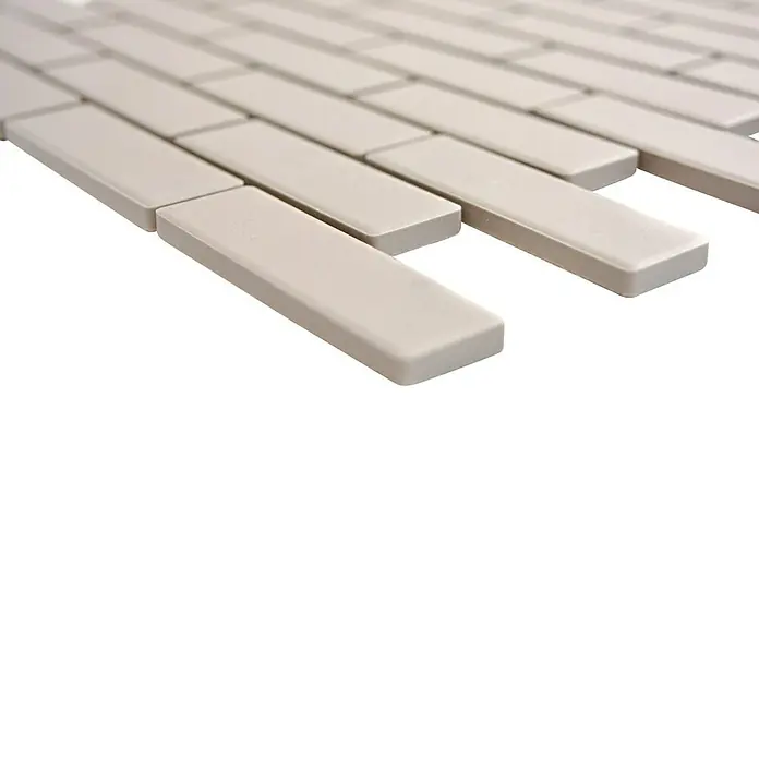 Mosaikfliese Brick Uni CU BR 304 - 26,1 x 29 cm, Hellgrau, Matt - Nahaufnahme von beigen, länglichen Mosaikfliesen, die ein schlichtes, elegantes Muster für Badezimmer oder Küchenrückwände bilden.