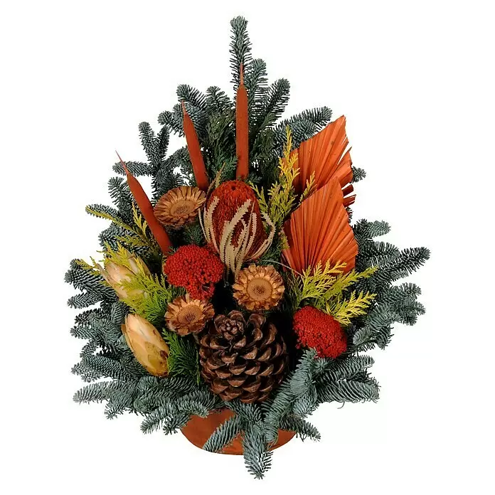Piardino Grabgesteck Nr. 255 - Stilrichtung: Klassisch, Mehrfarbig - Winterliches Blumenarrangement mit blaugrünen Tannenzweigen, Kiefernzapfen, getrockneten orangefarbenen und roten Botanicals, und einem Terrakotta-Sockel.