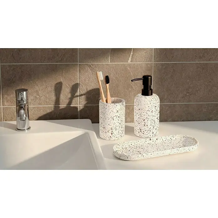 Camargue Seifenspender Stone Terrazzo - 7,5 x 7,5 x 18 cm, Polyresin, Beige/Braun - Ein Badezimmersatz mit Sprenkelmuster, bestehend aus Seifenspender, Zahnputzbecher und Seifenablage, elegant arrangiert auf einem Waschbecken.