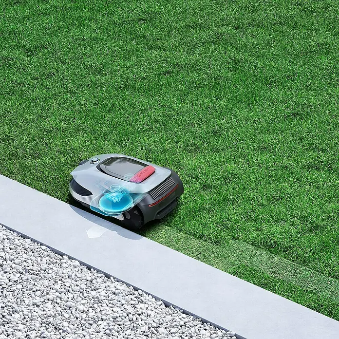 Dreame Mähroboter A2 2000 - 2.000 m², Schnittbreite: 22 cm, Laser-gestützte Navigation, LiDAR - Intelligenter Rasenmäher-Roboter der nächsten Generation auf Gras neben einer grauen Steinplatte und weißen Kieselsteinen.