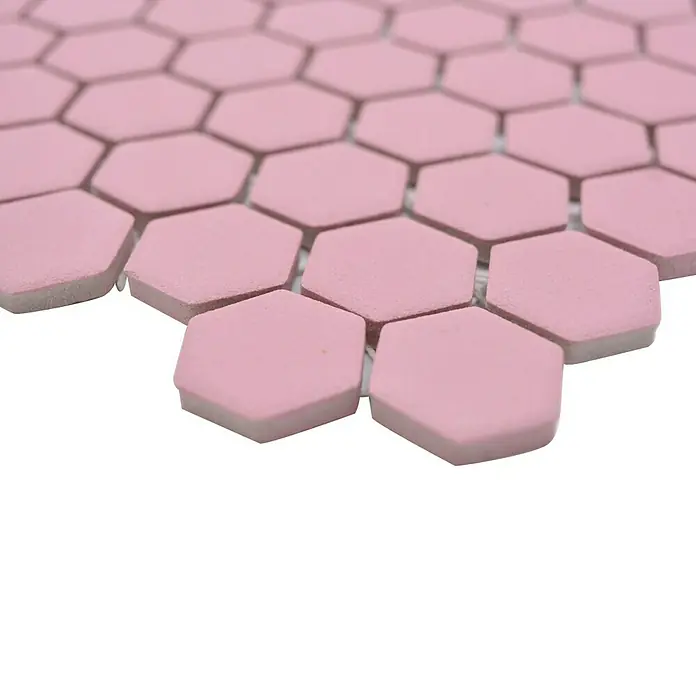 Mosaikfliese Hexagon Uni HX AT22 - 26 x 30 cm, Rosa, Matt - Nahaufnahme von rosa sechseckigen Mosaikfliesen, die ein geometrisches Muster auf einer weißen Oberfläche bilden, ideal für trendige Designs.