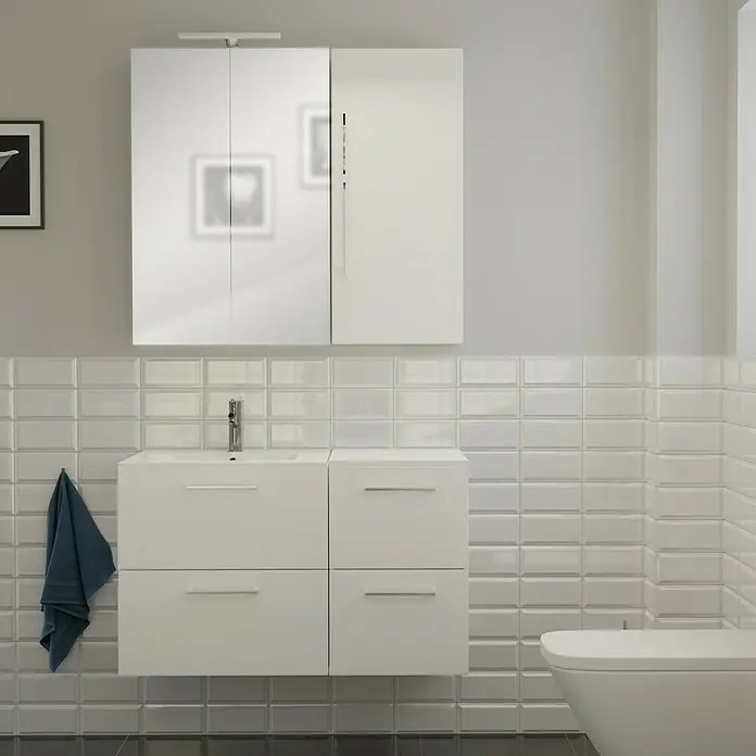 Camargue Espacio Badmöbel-Set i81 - 100 cm, Mira - Modernes Badezimmer-Interieur mit einem weißen Waschtischunterschrank und Spiegelschrank an einer weiß gefliesten Wand.
