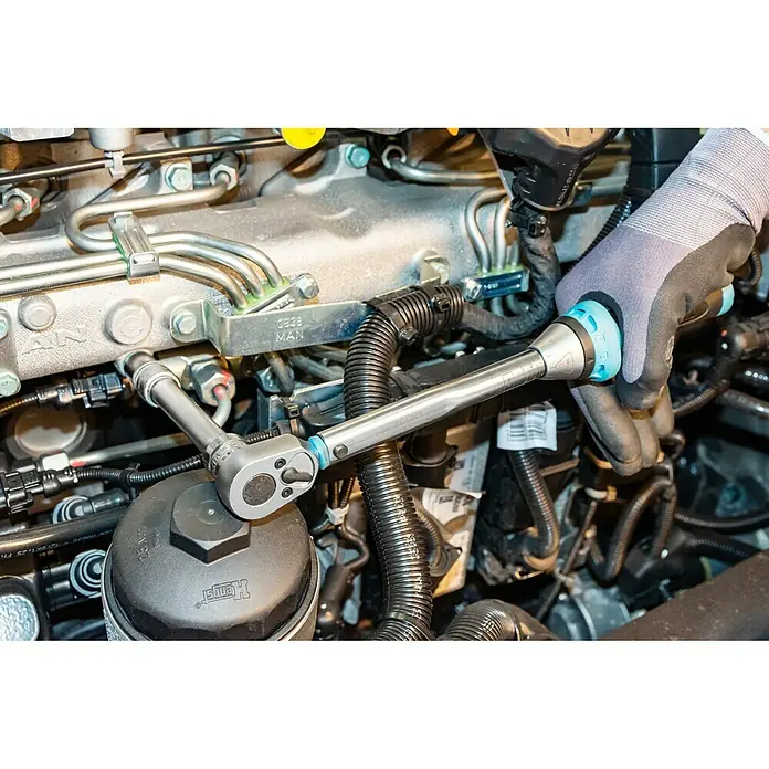 Hazet Drehmomentschlüssel 5120-3CT - ½″ Vierkant, 10 Nm - 60 Nm - Drehmomentschlüssel in Aktion an einem Automotor. Präzises Anziehen für optimale Leistung und Sicherheit.
