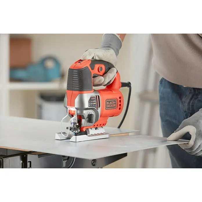 Black+Decker Sierra de calar eléctrica BES610K-QS - 1.000 /min - 3.100 /min, 90 mm - La sierra de calar BLACK+DECKER en acción, cortando un trozo de material. La herramienta eléctrica, naranja y negra, ofrece resultados precisos.