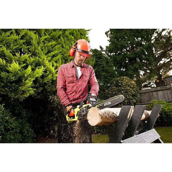 Ryobi Motosierra eléctrica RCS2340B - 2.300 W, Longitud de la cuchilla: 40 cm - Un hombre usa una motosierra Ryobi amarilla para cortar madera, con casco y guantes de protección.