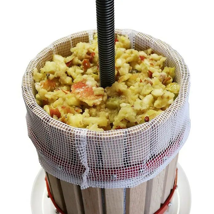 Güde Obstpresse OP 30 - Fassungsvermögen: 30 l - Eine Apfelpresse mit zerkleinerten Äpfeln in einem Netz, bereit zum Entsaften, ideal für frischen Apfelsaft.