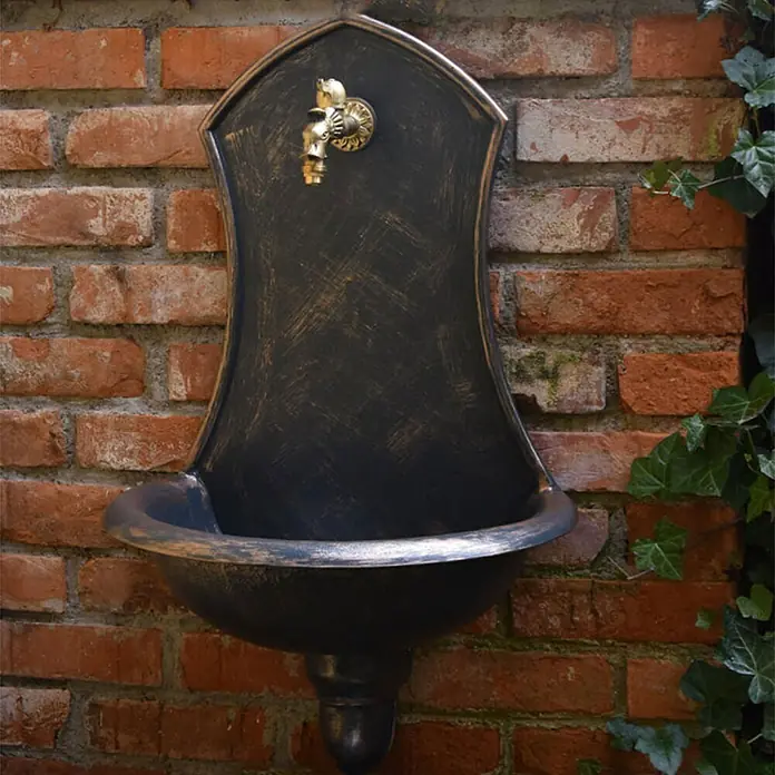 Roto Waschbecken Saturn - L x B x H: 53 x 38 x 75 cm, Braun, Kunststoff - Wandbrunnen aus Metall mit Wasserhahn und einem Becken, das an einer Ziegelmauer befestigt ist und mit Efeu umrankt ist.