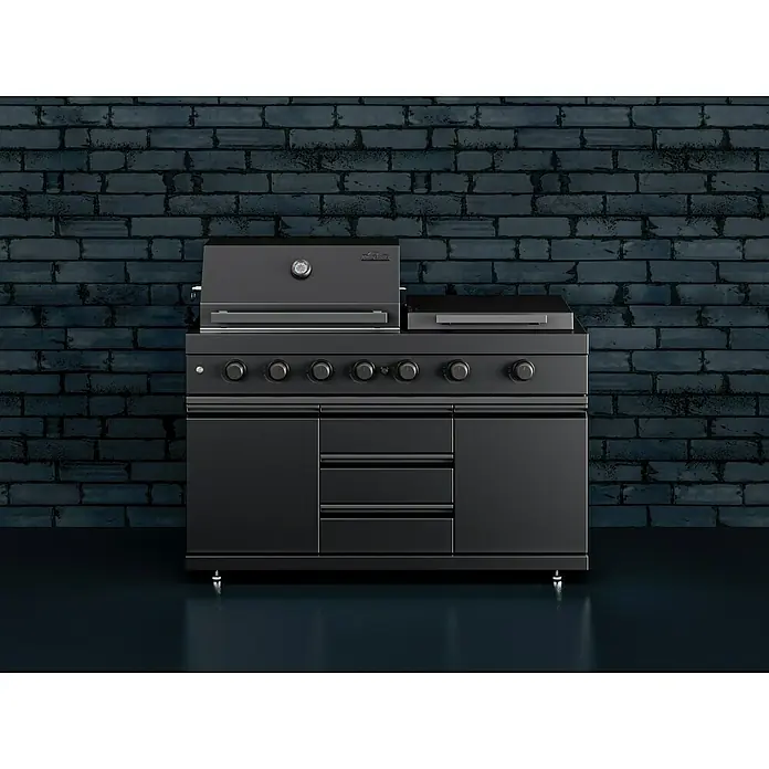Kingstone Cube Outdoorküche 4500 - Schwarz, Material Grillfläche: Gusseisen, Anzahl Brenner: 7 - Schwarzer Grill mit Unterschrank vor dunkler Backsteinwand. Das elegante Design macht ihn zum Highlight jeder Outdoor-Küche.