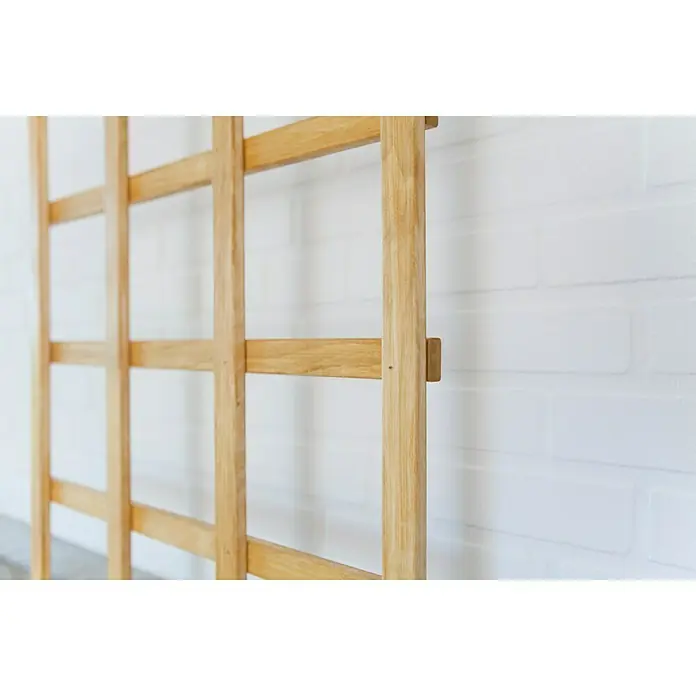Kiehnholz Rankgitter Aspe - Hellbraun, Höhe: 180 cm - Nahaufnahme einer Sprossenwand aus hellem Holz, ideal für Gymnastik und Klettern, an einer weißen Ziegelwand befestigt.