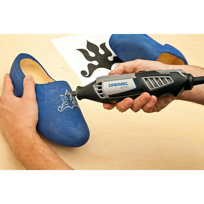 Dremel Fräsmesser 118 - Kegelkopf, Hartmetall, 2 Stk. - Das Dremel 4000 Werkzeug wird verwendet, um ein blaues Holzschuh zu verzieren, wodurch ein präzises und detailliertes Design entsteht.