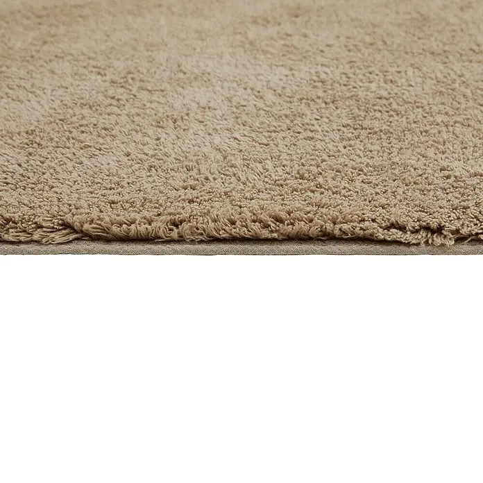 Badteppich Ibiza - 60 x 100 cm, Taupe, 100% Baumwolle - Nahaufnahme eines beigen, flauschigen Teppichs, der eine weiche Textur und eine neutrale Farbpalette für Wohnräume bietet.