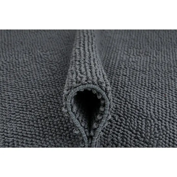Badteppich Atlanta - 60 x 100 cm, Anthrazit, 100% Baumwolle - Detailaufnahme einer grau gefalteten Badematte, die ihre weiche Textur und hochwertige Verarbeitung zeigt. Ideal für jedes Badezimmer.