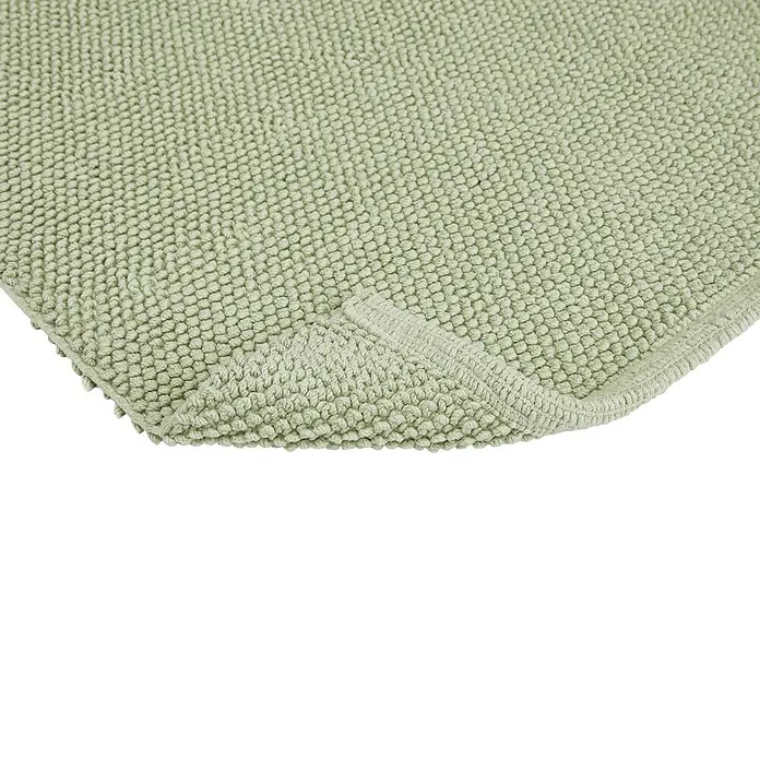 Badteppich Atlanta - 60 x 100 cm, Salbei, 100% Baumwolle - Detailaufnahme einer Badematte in sanftem Grün mit strukturierter Oberfläche und abgerundeter Ecke.