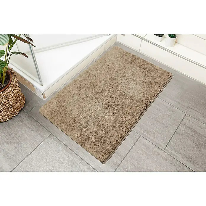 Badteppich Ibiza - 60 x 100 cm, Taupe, 100% Baumwolle - Flauschiger, brauner Badteppich liegt vor einer Dusche auf hellgrauen Fliesen und sorgt für warme Füße nach dem Duschen.