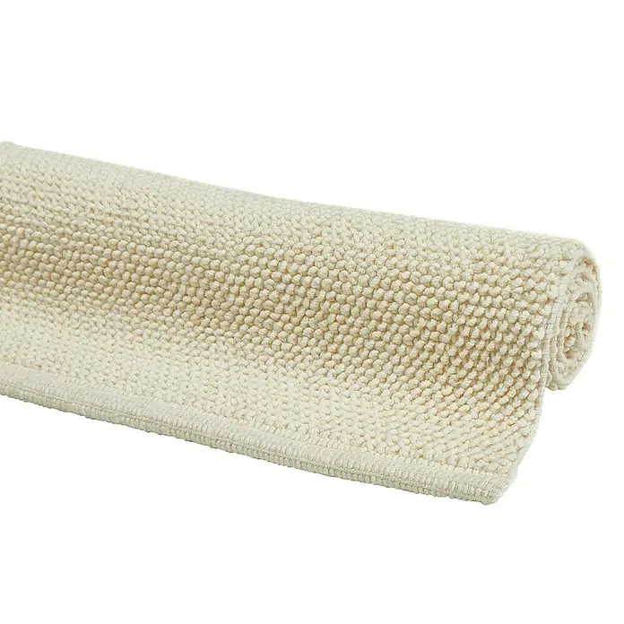 Badteppich Atlanta - 60 x 100 cm, Weiß, 100% Baumwolle - Nahaufnahme einer gerollten, cremefarbenen Badematte mit Textur, die weich und saugfähig aussieht. Ideal für Badezimmerböden.