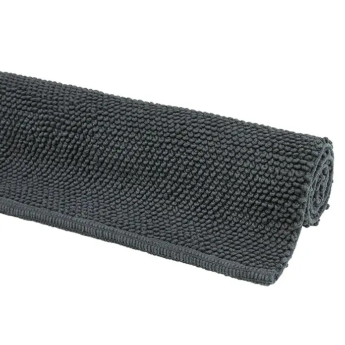Badteppich Atlanta - 60 x 100 cm, Anthrazit, 100% Baumwolle - Graue Badematte mit Noppenstruktur, teilweise aufgerollt. Ideal für ein stilvolles Badezimmer mit Komfort.
