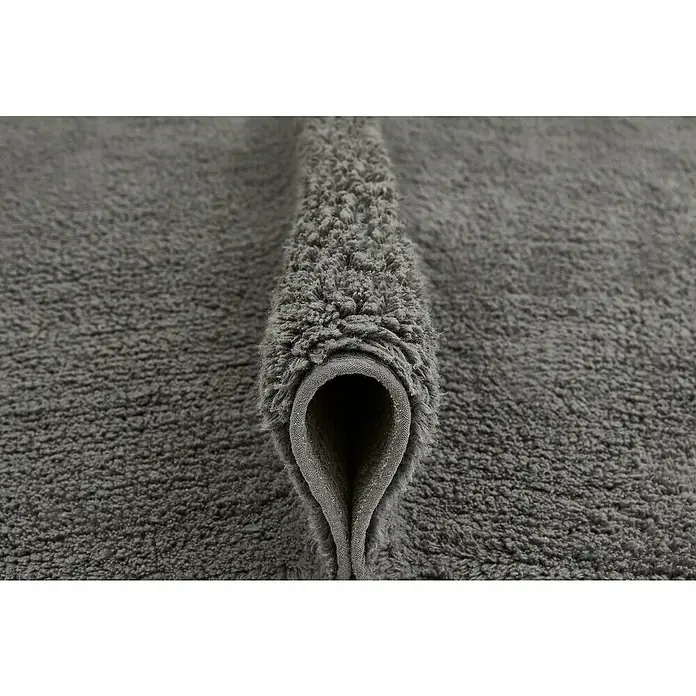 Badteppich Ibiza - 60 x 100 cm, Anthrazit, 100% Baumwolle - Nahaufnahme eines weichen, grauen Badeteppichs mit einer gefalteten Kante, die die Textur und Qualität des Materials hervorhebt.