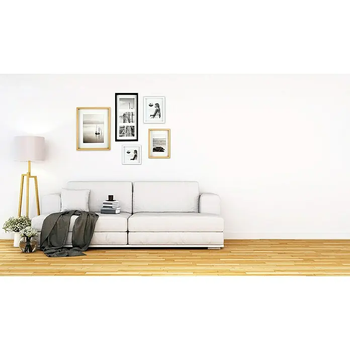 Accent Collagerahmen Aura - Anzahl Fotoplatzhalter: 3 Stk., Eiche, Holz - Eine elegante Wanddekoration mit einer Auswahl an gerahmten Bildern über einem modernen weißen Sofa, die stilvolles Wohnambiente schafft.