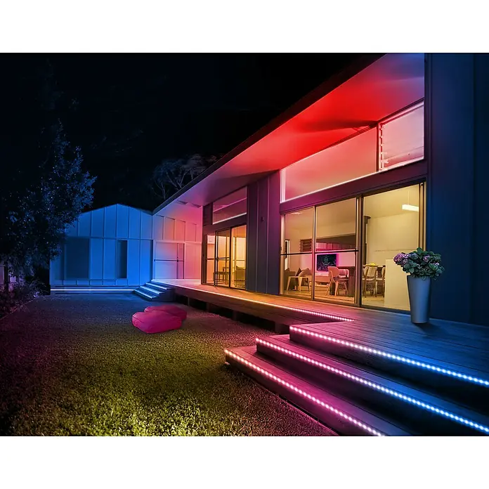 Osram Smart+ LED-Band Flex außen - Länge: 300 cm, Lichtfarbe: RGBW, 12,5 W, 740 lm, 220 V - 240 V - Ein Haus mit farbigen LED-Streifen, die architektonische Details hervorheben und eine moderne, einladende Atmosphäre schaffen.