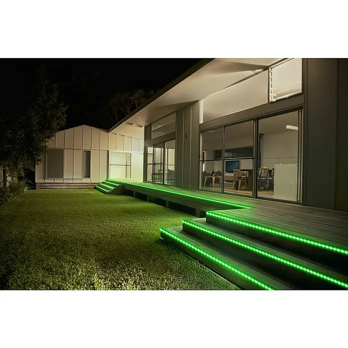 Osram Smart+ LED-Band Flex außen - Länge: 300 cm, Lichtfarbe: RGBW, 12,5 W, 740 lm, 220 V - 240 V - Außenansicht eines modernen Hauses mit grünen LED-Leuchten an der Terrasse, die die architektonischen Details hervorheben.