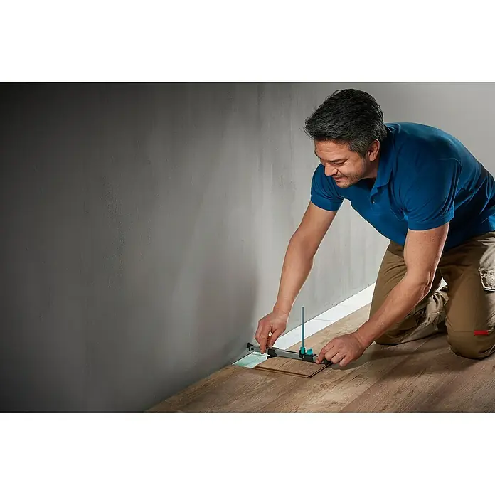 Wolfcraft Anreißlehre - Länge: 295 mm - Ein Mann verlegt Laminat mit einem Laminatschneider. Präzises Zuschneiden für passgenaue Ergebnisse bei der Laminatverlegung.