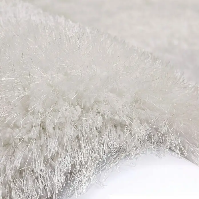 Kayoom Hochflorteppich Cosy - Weiß, 150 x 80 cm, 100 % Polyester - Detailaufnahme eines weichen, weißen Shaggy-Teppichs mit langen Fasern, der für Komfort und Wärme in jedem Raum sorgt.